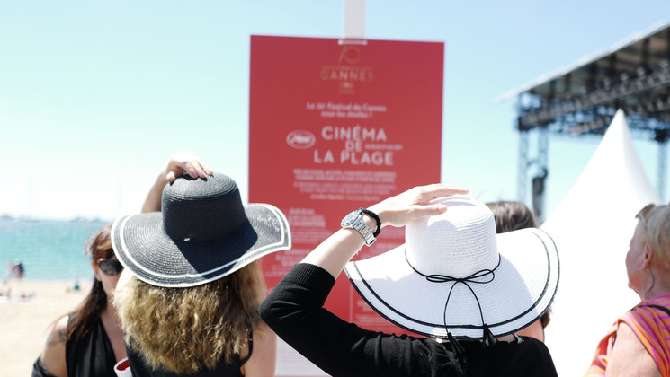 Passers-by look at the programme for the Cinéma de la Plage © Valery Hache / AFP